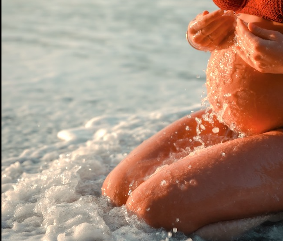 Shooting grossesse dans les vagues au coucher du soleil